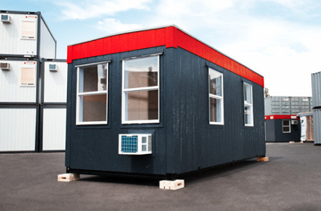 Casa modular de color negro con techo rojo, equipada con ventanas amplias y aire acondicionado. Ideal como vivienda prefabricada o segunda vivienda. Diseño contemporáneo y funcional. Marca Tecno Fast Home.
