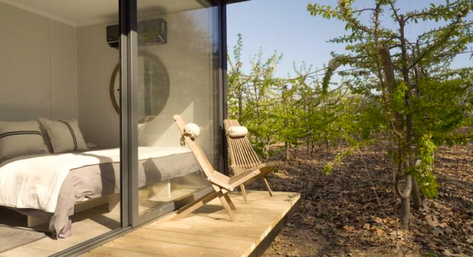 Un espacio exterior de una vivienda modular con sillas de madera, ideal para disfrutar del entorno natural. La casa prefabricada cuenta con grandes ventanales que permiten la entrada de luz. Perfecta como segunda vivienda. Tecno Fast Home.
---
Terraza de una casa modular con mobiliario de exterior, rodeada de vegetación. Este diseño de vivienda prefabricada destaca por su modernidad y funcionalidad, ideal para escapadas. Tecno Fast Home.
---
Vista de un balcón en una casa prefabricada, con cómodas sillas para relajarse en un entorno natural. Esta vivienda modular es la opción perfecta para quienes buscan un espacio acogedor. Tecno Fast Home.