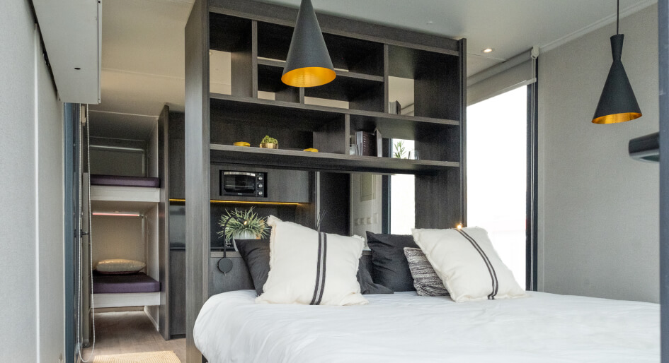 Diseño moderno y acogedor de un dormitorio en una vivienda modular, con una cama cómoda y estanterías integradas. La iluminación destaca en el ambiente, creando un espacio ideal para el descanso. Casa prefabricada de estilo contemporáneo. Tecno Fast Home.
---
Espacio interior de una casa modular que muestra un dormitorio elegante y funcional, con elementos de almacenamiento y una atmósfera cálida. Ideal como segunda vivienda o refugio vacacional. Tecno Fast Home.