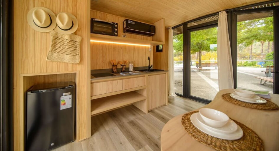 Cocina moderna y funcional en una vivienda modular, con acabados en madera y electrodomésticos integrados, ideal para una casa prefabricada o segunda vivienda. Tecno Fast Home.