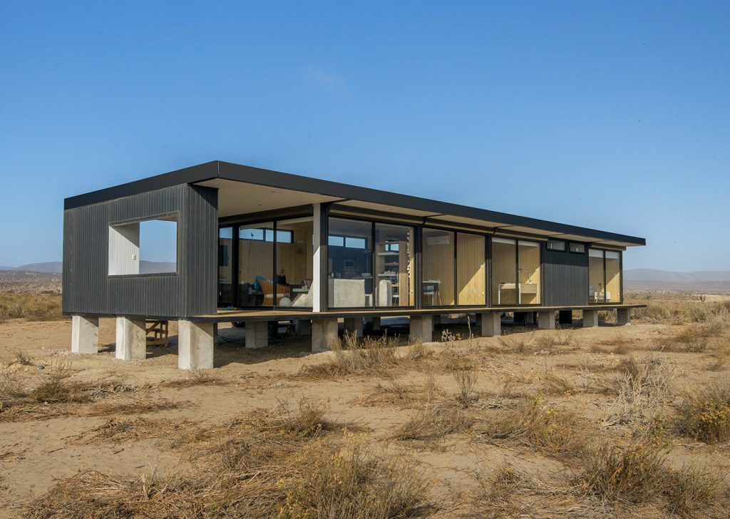 Vivienda modular contemporánea con amplios ventanales y estructura elevada, ideal para disfrutar de la naturaleza. Este diseño de casa prefabricada resalta la funcionalidad y el estilo. Perfecta como segunda vivienda. Tecno Fast Home.