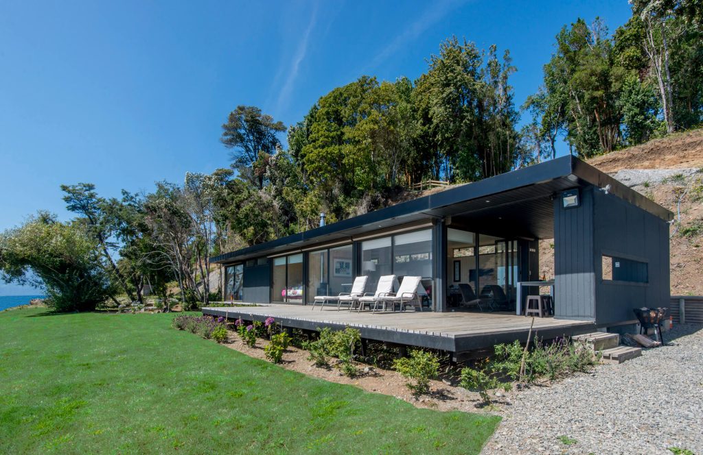 Casa modular contemporánea rodeada de naturaleza, con un amplio deck y espacios exteriores ideales para disfrutar del aire libre. Esta vivienda prefabricada ofrece un diseño moderno y funcional, perfecta como segunda vivienda. Tecno Fast Home.