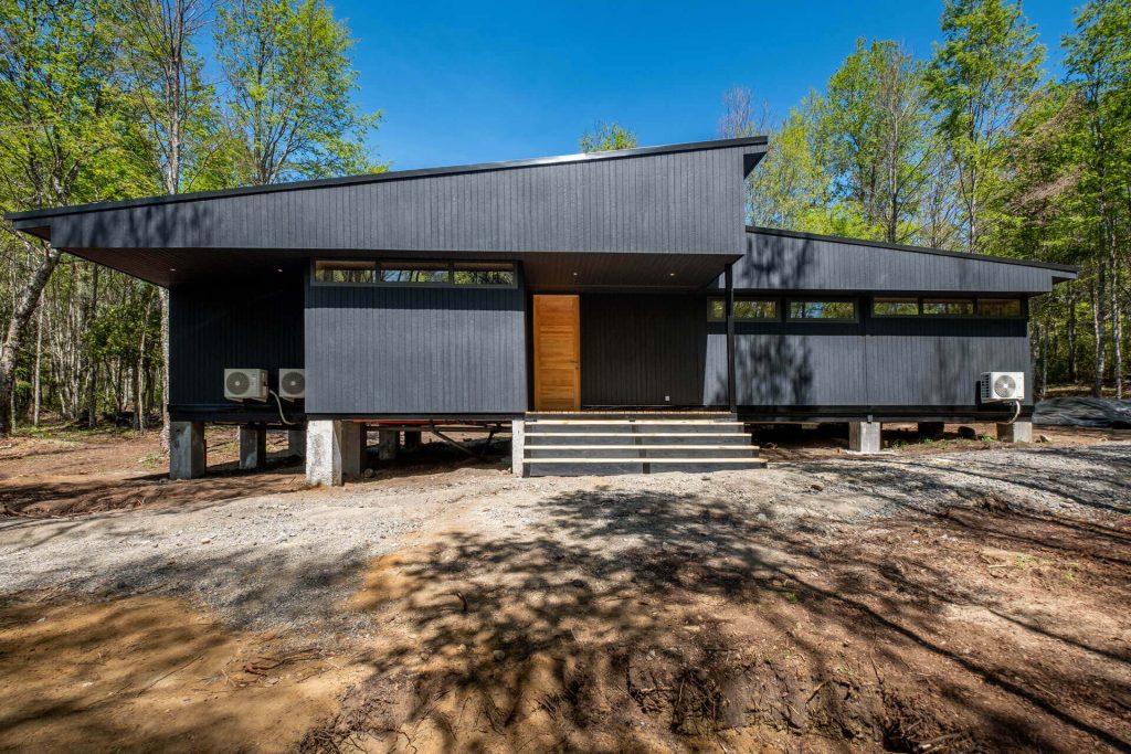 Entrada acogedora de una vivienda modular con puerta de madera y detalles decorativos. Ideal para quienes buscan una casa prefabricada que combine estética y funcionalidad. Tecno Fast Home.