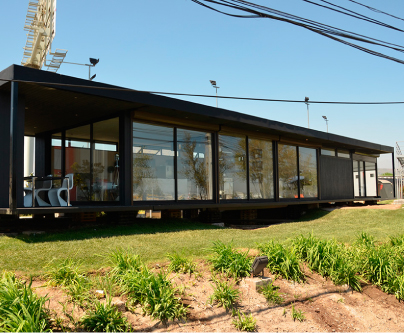 Vivienda modular con amplias ventanas que permiten una excelente iluminación natural, ideal como casa prefabricada para disfrutar de la naturaleza. Esta segunda vivienda ofrece un diseño moderno y funcional, perfecto para escapes de fin de semana. Tecno Fast Home.