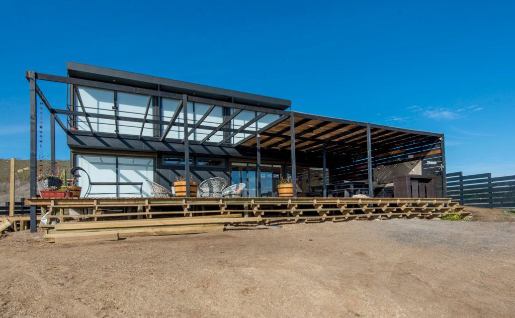 Casa modular con estructura moderna y amplios ventanales, ideal como vivienda principal o segunda vivienda. Diseño contemporáneo que maximiza la luz natural y la conexión con el entorno. Marca Tecno Fast Home.