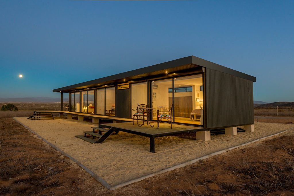 Casa modular con diseño moderno y amplio porche, ideal para disfrutar del entorno natural. Esta vivienda prefabricada combina funcionalidad y estilo, perfecta como segunda vivienda. Tecno Fast Home.