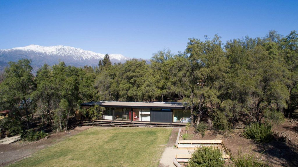 Casa modular rodeada de un amplio jardín y árboles, destacando su diseño moderno y funcional, ideal como segunda vivienda o espacio de descanso. Marca: Tecno Fast Home.