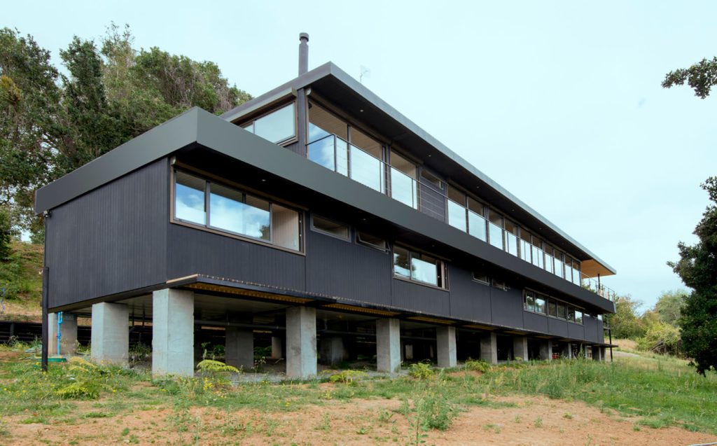 Casa modular de diseño contemporáneo, construida sobre pilotes, con amplias ventanas que permiten la entrada de luz natural. Ideal para quienes buscan una segunda vivienda en un entorno natural. Marca Tecno Fast Home.