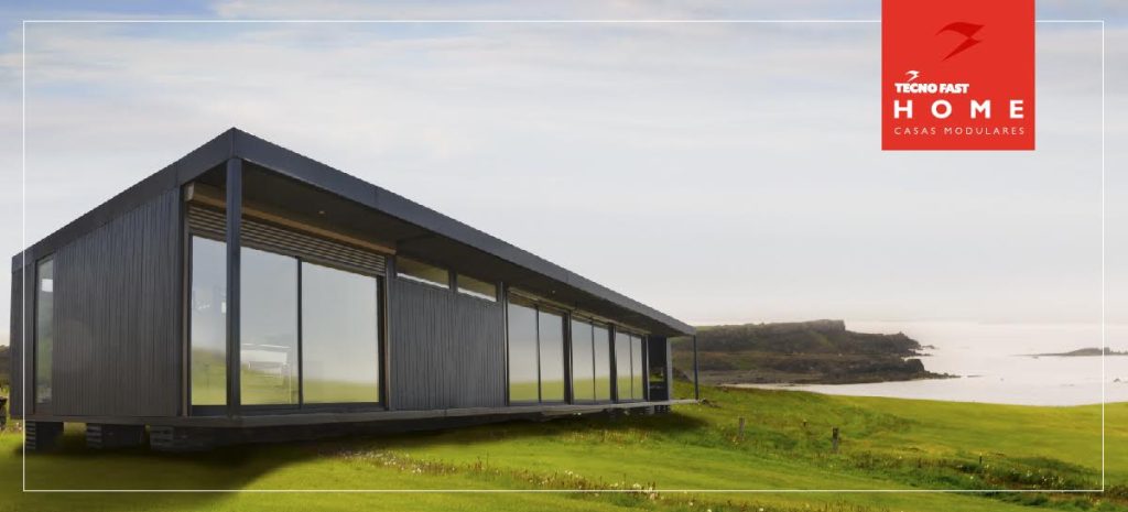 Vista exterior de una vivienda modular con amplios ventanales, ubicada en un entorno natural. Su diseño contemporáneo y funcional la convierte en una opción ideal como casa prefabricada o segunda vivienda. Ideal para disfrutar de la tranquilidad del campo. Tecno Fast Home.