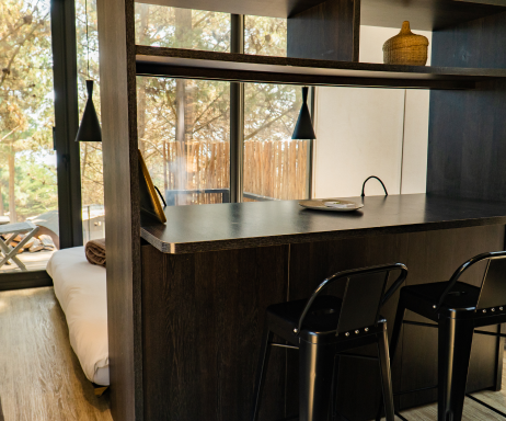 Espacio interior de una vivienda modular con un diseño contemporáneo, que incluye una barra de cocina y asientos elegantes. Ideal para quienes buscan una casa prefabricada funcional y acogedora. Tecno Fast Home.