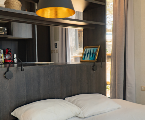 Interiores de una vivienda modular con un diseño moderno, destacando una cama con almohadas blancas y una lámpara elegante. Espacio acogedor ideal para una segunda vivienda. Tecno Fast Home.

Un rincón de una casa prefabricada que muestra un ambiente contemporáneo, con mobiliario funcional y una decoración minimalista. Perfecto como espacio de descanso en una casa modular. Tecno Fast Home.