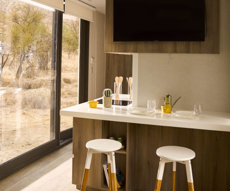 Cocina moderna en una vivienda modular, con una barra de desayuno y un ambiente luminoso gracias a grandes ventanales. Ideal para disfrutar de momentos familiares en una casa prefabricada. Tecno Fast Home.