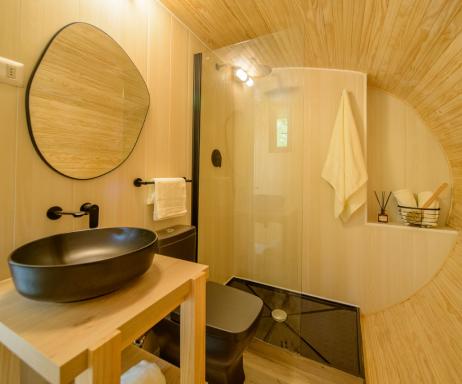 Baño moderno en una vivienda modular, con acabados en madera y diseño minimalista. Incluye un lavabo de estilo contemporáneo y una ducha amplia. Ideal para una casa prefabricada o una segunda vivienda. Tecno Fast Home.