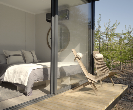 Una acogedora habitación en una vivienda modular, con grandes ventanales que permiten la entrada de luz natural. El mobiliario minimalista y la decoración moderna crean un ambiente relajante. Ideal como segunda vivienda o espacio de descanso. Tecno Fast Home.

---

Espacio interior de una casa prefabricada, donde se aprecia un diseño contemporáneo y funcional. La combinación de madera y vidrio aporta calidez, perfecto para disfrutar de un refugio en la naturaleza. Tecno Fast Home.

---

Una terraza de una casa modular, diseñada para disfrutar del aire libre. La silla de diseño ergonómico invita a relajarse mientras se contempla el paisaje circundante, ideal para una segunda vivienda. Tecno Fast Home.