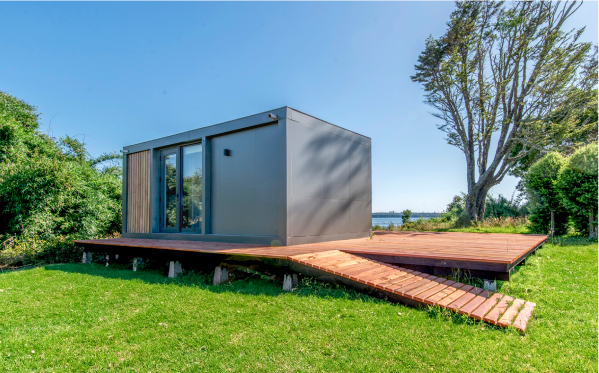 Casa modular contemporánea ubicada en un entorno natural, con un diseño elegante y funcional. La vivienda cuenta con amplios ventanales que permiten la entrada de luz natural y una conexión fluida con el exterior. Ideal como segunda vivienda o para disfrutar de escapadas de fin de semana. Marca: Tecno Fast Home.