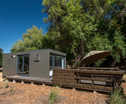 Casa modular con diseño moderno, rodeada de naturaleza, ideal como segunda vivienda o espacio de descanso. Su estructura funcional y eficiente se integra perfectamente en el entorno. Tecno Fast Home.