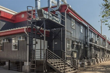 Estructura de vivienda modular con escaleras exteriores y diseño contemporáneo, ideal para proyectos de construcción rápida. Este modelo puede servir como casa prefabricada o como una segunda vivienda funcional. Tecno Fast Home.