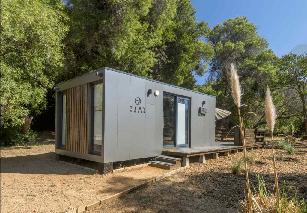 Casa modular contemporánea con diseño minimalista, ubicada en un entorno natural, ideal como segunda vivienda o refugio. Su estructura de materiales sostenibles y acabados de alta calidad la hacen perfecta para quienes buscan comodidad y estilo. Marca: Tecno Fast Home.