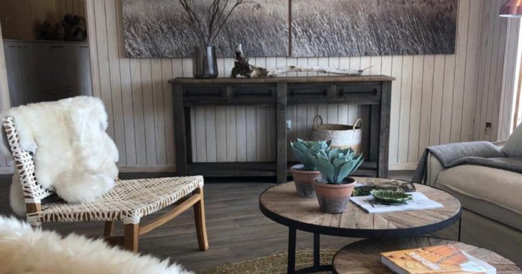 Interior acogedor de una vivienda modular con un estilo minimalista, donde se destacan elementos de madera y decoración natural. La cómoda silla tejida y la mesa de café de diseño rústico crean un ambiente cálido. Esta casa prefabricada invita a disfrutar de momentos de tranquilidad. Tecno Fast Home