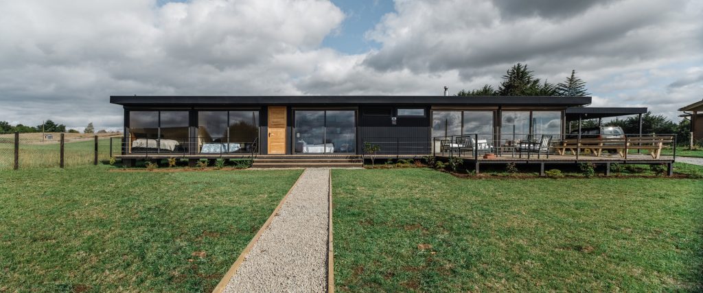Casa modular moderna con amplios ventanales y un diseño elegante, ideal para disfrutar de la naturaleza. Rodeada de un jardín bien cuidado, esta vivienda prefabricada ofrece comodidad y estilo. Perfecta como segunda vivienda o para quienes buscan un hogar sostenible. Tecno Fast Home.